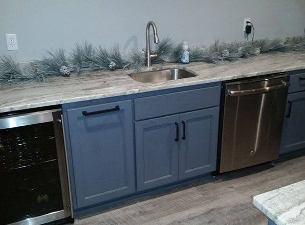 blue doors on back bar with diswasher wine fridge and sink. Basement Remodeling. Johnson County Remodeling.