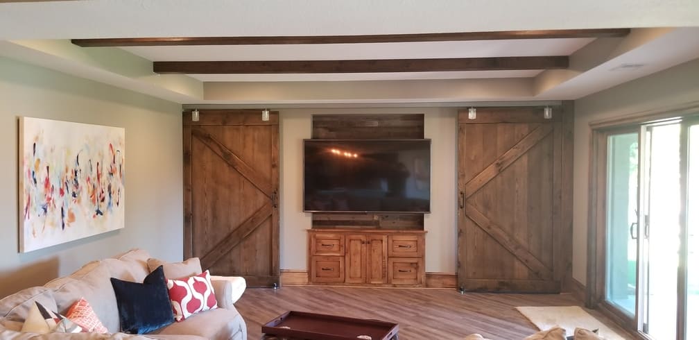 Large screen tv with barn doors covering the windows. Basement Remodeling. Johnson County Remodeling.